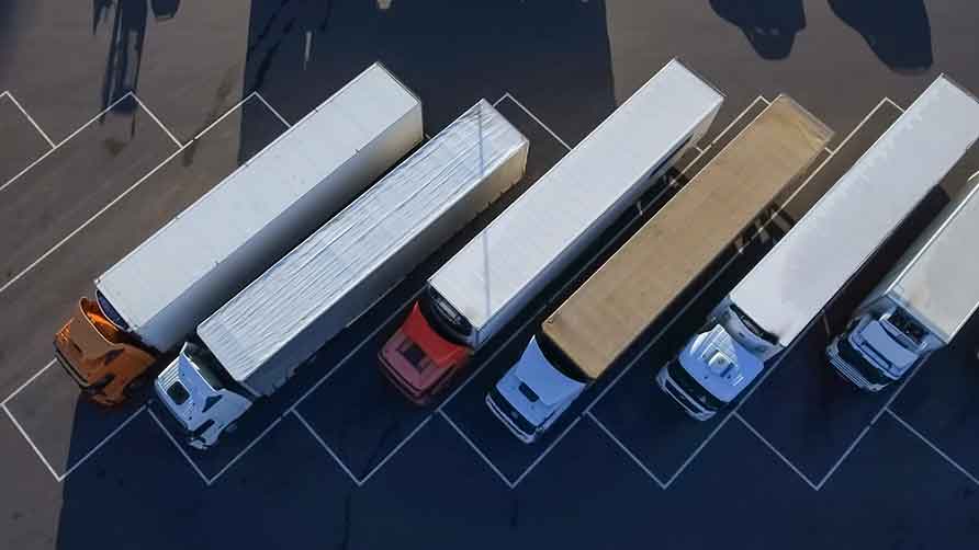 Esta imagen muestra una vista de pájaro de camiones alineados en un estacionamiento.